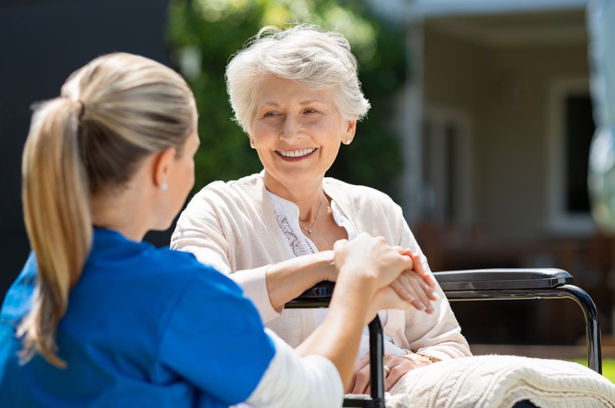 A caregiver with an older woman outdoors