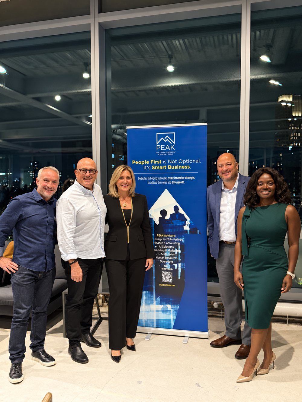 Colleen Ferrary and four colleagues in front of a Peak banner in New York